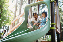 father and daugter on a playground slide